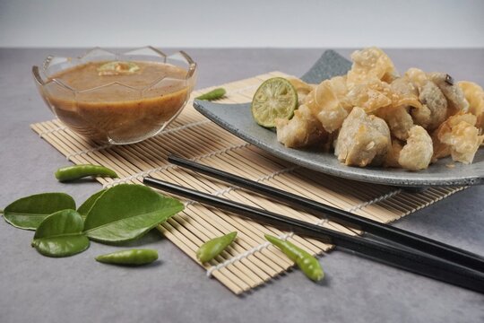 Batagor or baso Tahu Goreng. Indonesian Traditional Street Food Fried Dumpling Made from Fish with Tapioca Flour, Tofu, and Dumpling Wrapper. Served with Spicy Peanut Sauce, Sweet Soy Sauce, and Lime 