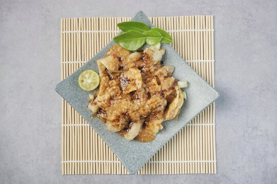 Batagor or baso Tahu Goreng. Indonesian Traditional Street Food Fried Dumpling Made from Fish with Tapioca Flour, Tofu, and Dumpling Wrapper. Served with Spicy Peanut Sauce, Sweet Soy Sauce, and Lime 