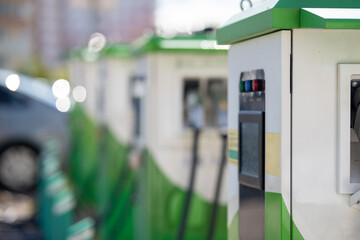 Close-up of an electric vehicle charging station with indicator lights and display.