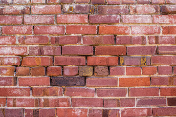 Fototapeta premium Brick wall with faded paint makes for unique texture