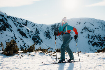 Mountaineer backcountry ski walking ski alpinist in the mountains. Ski touring in alpine landscape with snowy trees. Adventure winter sport. Low Tatras, slovakia