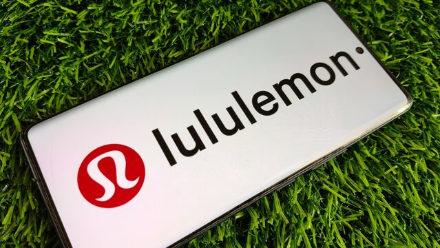 Lululemon logo on mobile phone screen on grass background