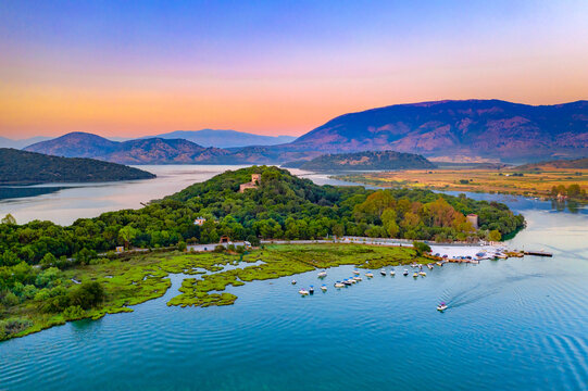 Butrint National Park with Venetian castle, lagoon and Bufi river with ferry crossing, Butrint, Albania at sunset.