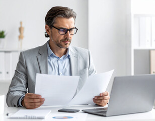 Seriöser Geschäftsmann arbeitet im Büro und schaut in Unterlagen