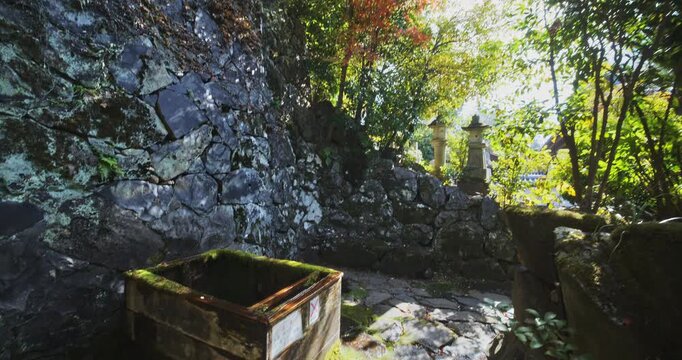 Colorful autumn area with stone walls and water dripping from wood faucet into box