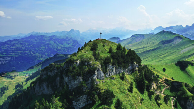 Aerial panoramic view of the Fronalpstock summit cross and the famous ridge hiking trail in the Swiss Alps, Stoos region