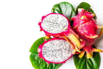 Two pitaya fruits with green leaves on white table. Ripe dragon fruit or pitahaya. Tropical fruits food, top view