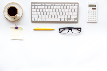 Home office workspace with computer keyboard and cup of coffee on white background, top view. Education online. Tabletop of freelancer.