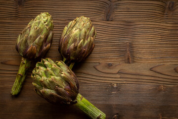Top view of tree whole heads of purple artichokes. Vegetable ready to cook