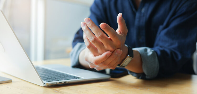 close up employee man massage on his hand and arm for relief pain from hard working ,carpal tunnel syndrome concept