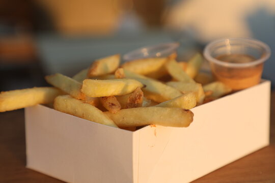 Frites servies avec sauces dans une bo&icirc;te blanche