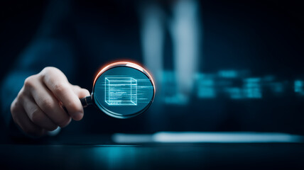 Hand holding a magnifying glass over a digital cube to represent data inspection and cybersecurity audit.
