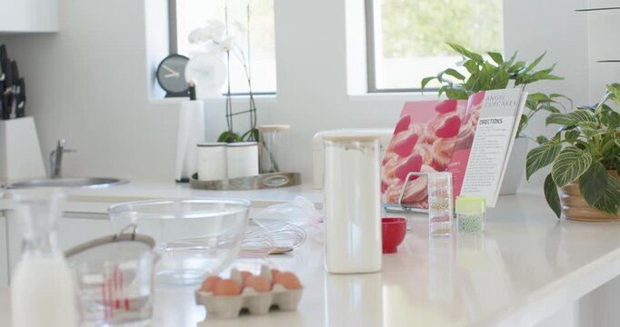 Camera is moving closer right, revealing baking prep on countertop, centering eggs, bowls, canister