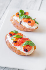 Gourmet bruschetta with stracciatella cherry tomatoes basil and balsamic on bright rustic background
