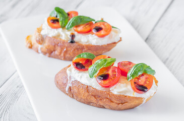 Gourmet bruschetta with stracciatella cherry tomatoes basil and balsamic on bright rustic background