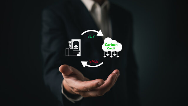 Businessman hand showing carbon credit trading cycle icon. Concept of buying and selling carbon offsets, market economy, and net zero emission strategy.