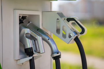 Close-up of EV charging station connectors and cables mounted in the charger.