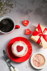 Valentine's Day festive cake with red heart, cup of coffee, gift box and candles. Copy space