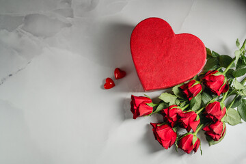 Valentine's Day background. Red roses flowers and heart gift box on bright background. Festive greeting card, flat lay