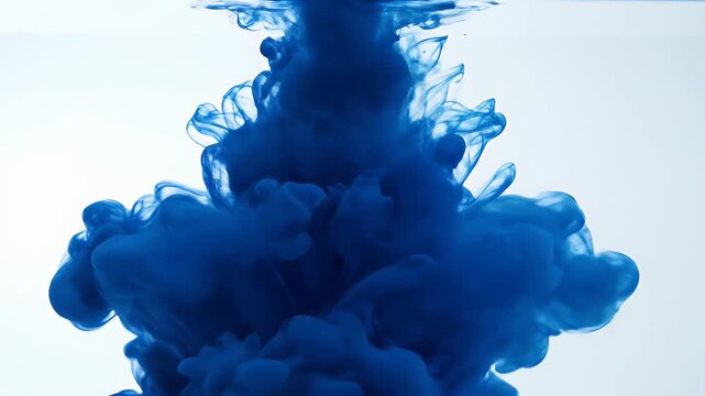 Blue Ink Cloud in Water - A mesmerizing shot shows a dense cloud of blue ink gracefully dispersing in clear water.