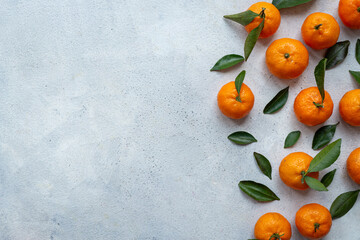 Top view layout of a mini tangerines - mandarin oranges - with green leaves. Juicy citrus background