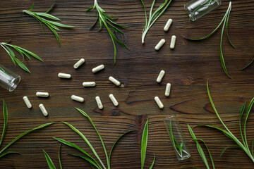 Alternative medicine, medicinal herbs for essences and tablets. Green leaves and a glass bottle for essential oils.