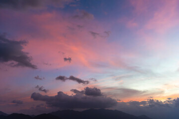 Bright sunset over the silhouette mountains at evening time.