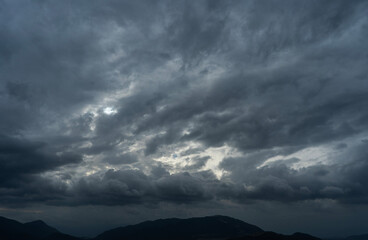 Bright sunset over the silhouette mountains at evening time.