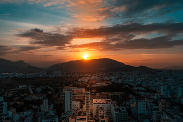 Bright sunset over the city and mountains at evening time.