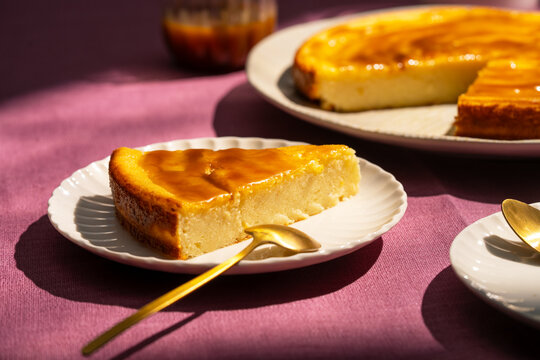 Ricotta cheesecake slice on white plate with purple cloth