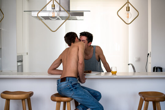 Gay couple sharing a tender moment in modern kitchen