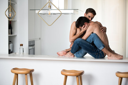Intimate Gay Couple Sitting Together on Kitchen Countertop