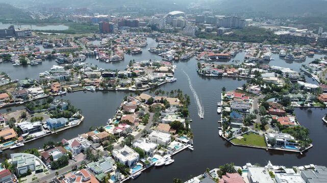 Drone panorama of Pueblo Viejo residential canals in Lecher&iacute;a, Venezuela, highlighting marina lifestyle, coastal urban design and leisure boating.