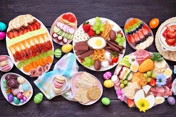 Fotobehang Eten Spring or Easter grazing board theme table scene against a dark wood background. Top down view. Selection of sweets and cheese, meat and fruit appetizers.  © Jenifoto