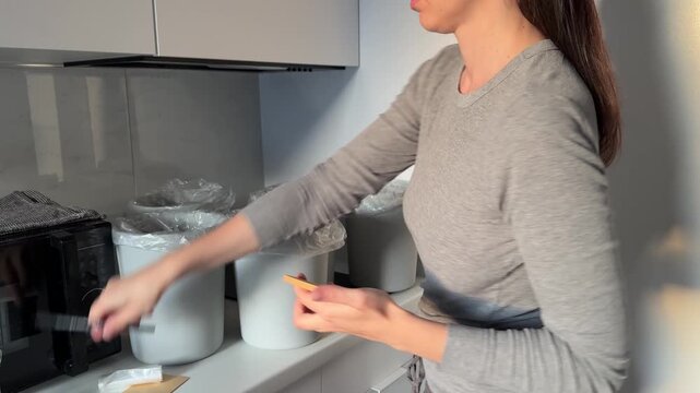 Waste sorting organization at home. Сonscious approach to consumption, eco responsibility, sustainable lifehacks. Woman organizing waste segregation at home.