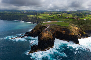 Landscape impressive rugged rocks with lighthouse and Atlantic ocean in norther part Sao Miguel island, Azores