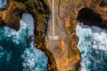 Scenic rugged rocks on Atlantic ocean coast with small lighthouse Fenais da Ajuda on Azores, Sao Miguel island. Aerial view