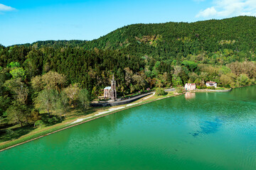 Drone view of neo Gothic chapel set at forest edge in Furnas valley on Sao Miguel island