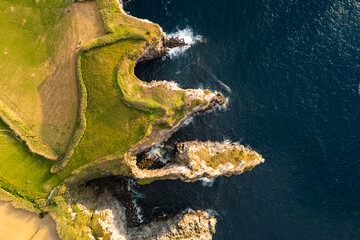 Rugged Atlantic shore with volcanic arches and steep cliff faces at Cape Cintrao, Sao Miguel. Azores aerial drone