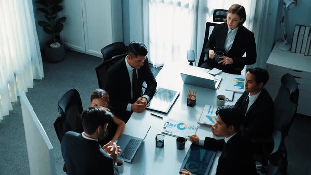 Top view of skilled project manager shake hand and invite business man to talking about marketing plan. Smart investor standing at whiteboard and analysis financial graph at meeting room. Directorate.