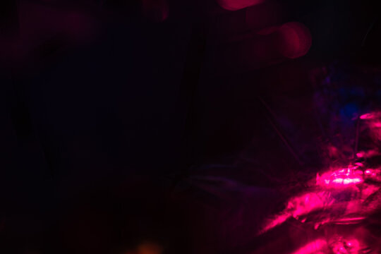 Moody dark abstract background with neon pink and magenta light reflections, creating a dreamy futuristic atmosphere for creative designs and backdrops.
