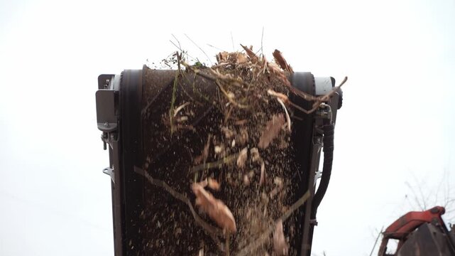 A wood chipper shreds wood into one pile. Branches and wood received at the composting station are crushed on a crusher to a fine fraction.