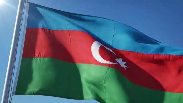 Azerbaijan flag waving in the wind against a clear blue sky with sun flare