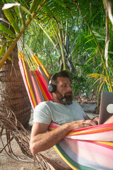 Digital Nomad Working on Laptop in Hammock on Tropical Beach