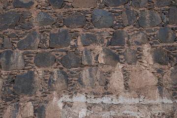 Ancient rustic volcanic stone wall texture background for design