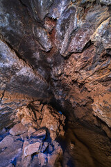 Lava Tube Interior With Volcanic Rock Formations and Shadowed Cavern Ceiling