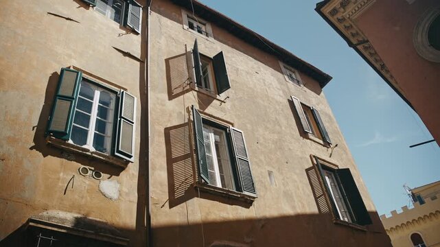 A shot of a older building with windows open to the allow the sun light in. Rome, Italy.