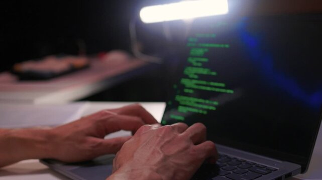 Developer working under dim light. Night coding session with glowing screen and quiet ambiance. Focused programmer typing code during late night debugging under subtle lighting