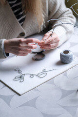 Female hands making handmade beaded jewelry