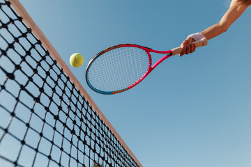 Tennis Racket Hitting Ball Over Net on Outdoor Court © st.kolesnikov